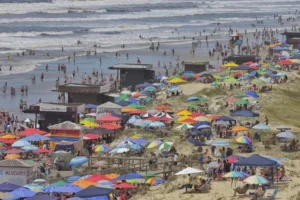 Veranistas ocupam o calçadão e as dunas de Capão da Canoa para fugir da ressaca no mar