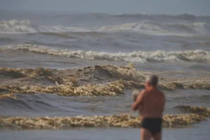 Veranistas encontram mar “chocolatão” em Capão da Canoa nesta Segunda-feira