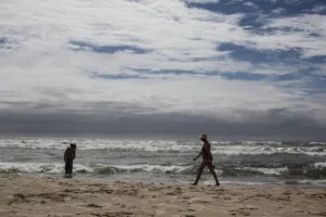 Após amanhecer chuvoso, veranistas ocupam a beira da praia de Tramandaí neste sábado