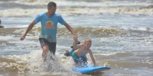 Escolinha de surf para crianças é retomada na beira da praia de Tramandaí