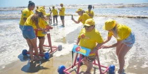 Andadores plásticos proporcionam banho de mar com alegria a pessoas com deficiência