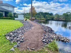 CONTENÇÃO DE PEDRAS É FEITA POR CONDOMÍNIO EM OSÓRIO, PARA BARRAR INVASÃO DE ÁGUA DA LAGOA