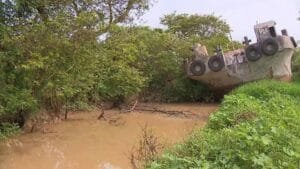 Embarcação encalhada desde a enchente bloqueia canal de irrigação de arroz em fazenda de Triunfo
