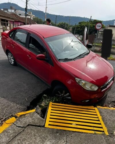 Veículo cai em buraco após asfalto ceder em rua movimentada de Osório