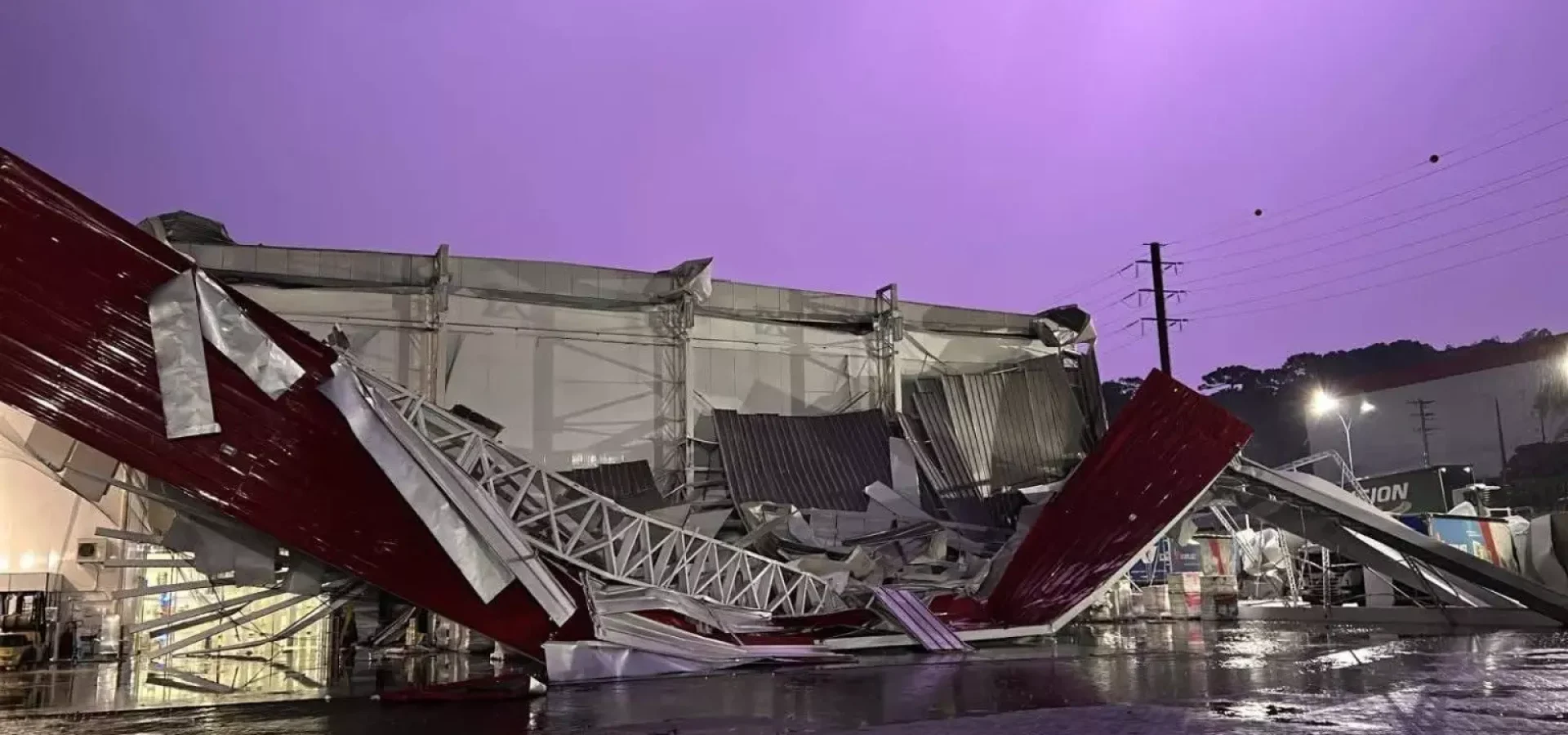 Um vendaval extremamente forte atingiu uma cidade de Santa Catarina, derrubou uma grande estrutura industrial, destelhou casas e provocou destruição. Defesa Civil investiga possível. microexplosão.